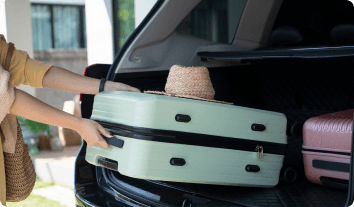 a suitcase being loaded into a trunk