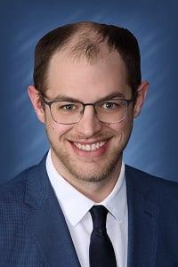 a man wearing glasses and a suit