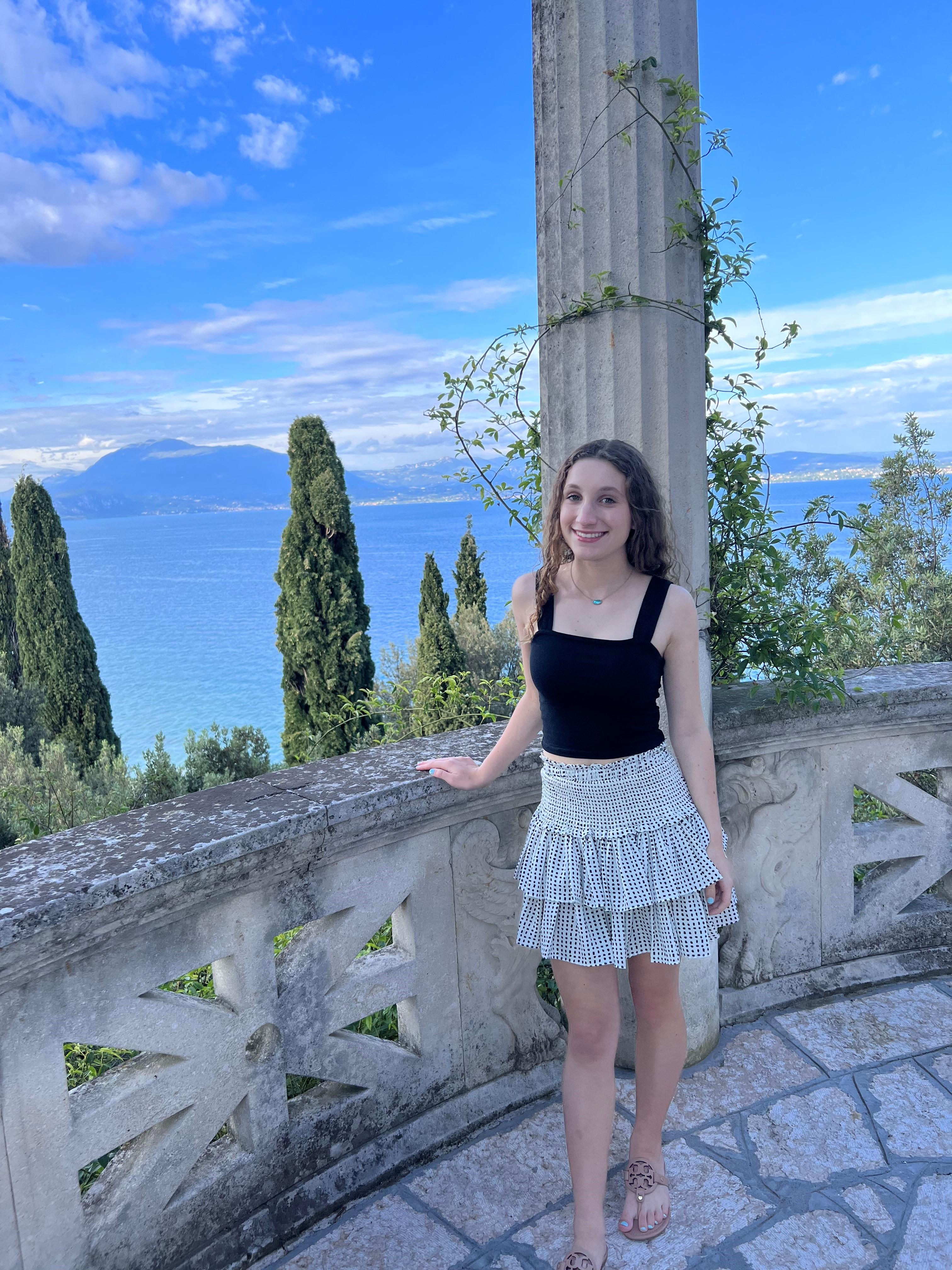 a woman standing on a stone wall