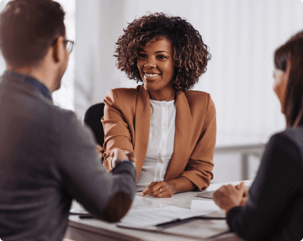 Businesspeople shaking hands across a desk. 