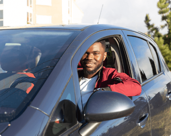 A happy driver sitting behind the wheel of his new vehicle.