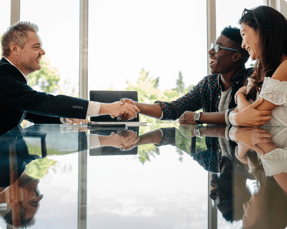 a couple shaking hands with a banker