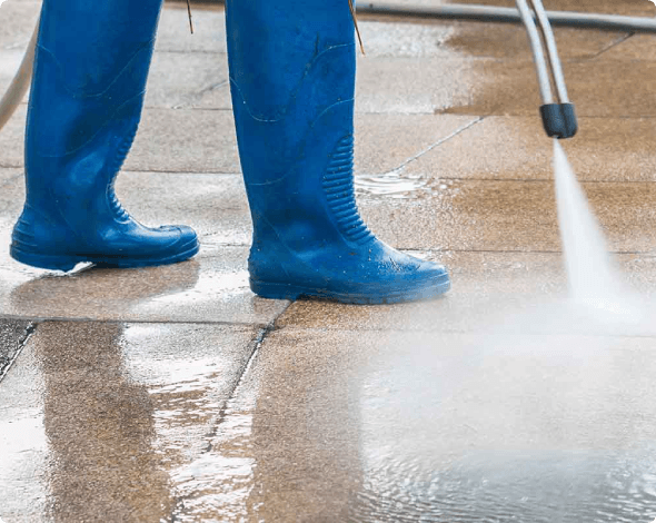 a person power washing a driveway