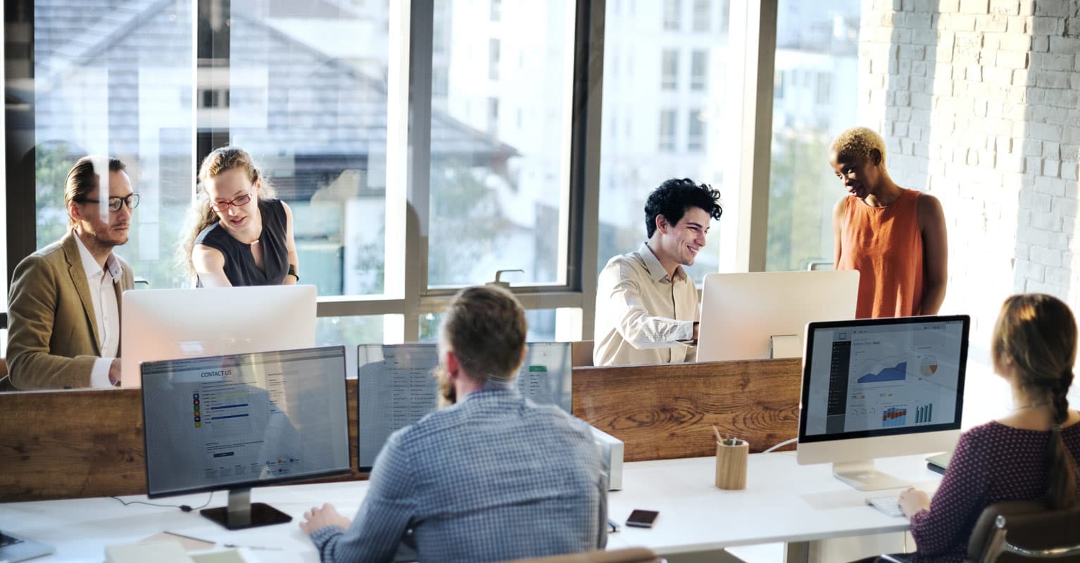 People in an office working on their computers and staying safe from cybercrime