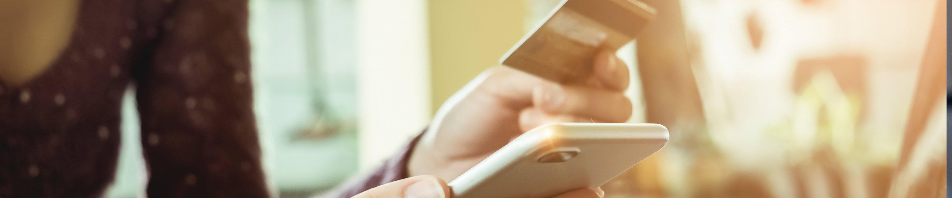 Woman purchasing an item on her phone with credit card.