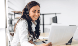 a woman smiling at a computer