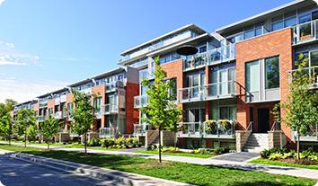 a multi-story building with trees and grass