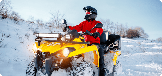 A rider riding an ATV in the snow