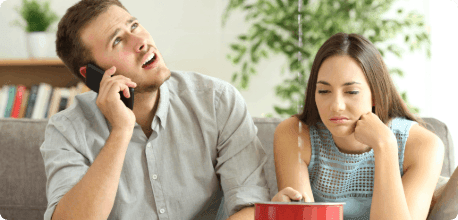 A close-up of a couple sitting under a leaking roof.