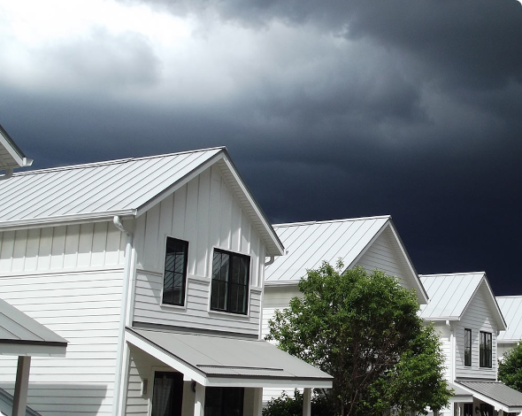 a row of houses with dark, ominous clouds above them