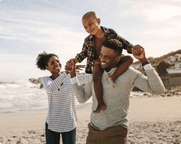 A happy family walking on a beach. 